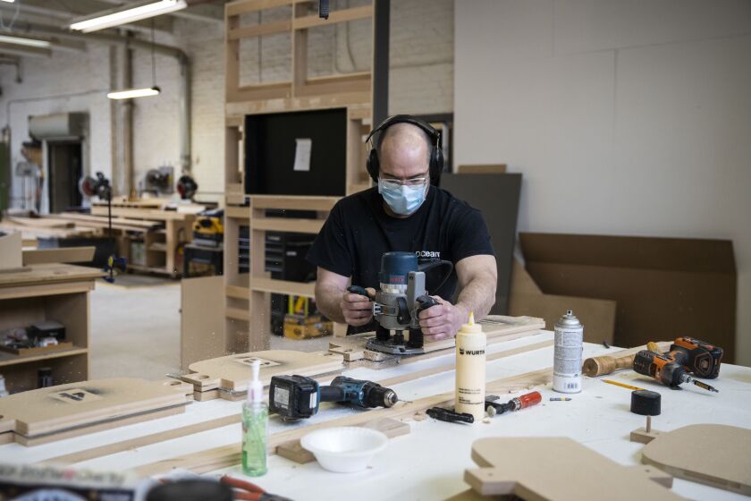 Jason Wade, lead carpenter at Pac Team, uses a template to cut plastic for face shields at the factory at 4447 W. Armitage Ave.
