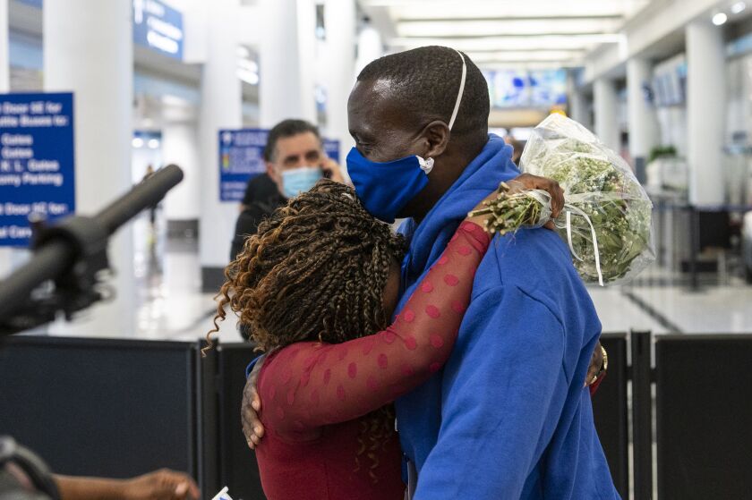 Mapenzi Mweniake, left, hugs her husband Mwenebatu Mwenemkaba, at O’Hare International Airport’s Terminal 5, Wednesday.