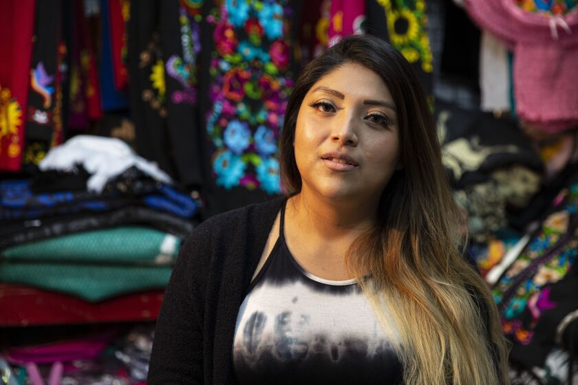 Daniela China, a vendor at the Little Village Discount Mall, sits inside her stall inside the neighborhood icon on West 26th Street.