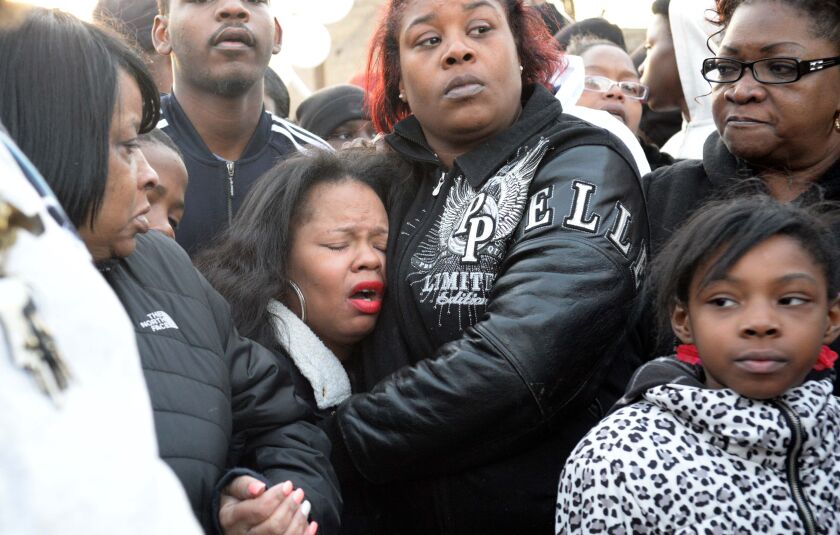 Tambrasha Hudson (center, eyes closed), the mother of 16-year-old Pierre Loury, attends a vigil the day after her son was shot and killed.