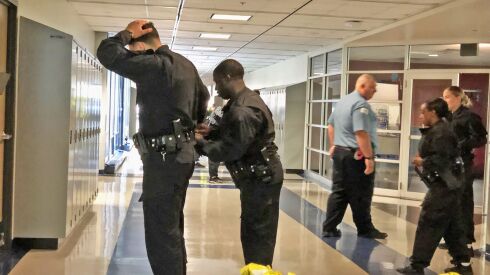 Practicing apprehending a suspect in a hallway.