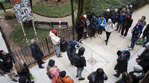 People look at the memorial for Paul Hardwick, a Black waiter at the Palmer House Hotel who was fatally shot while being chased by a mob of white men, during a walking tour organized by the Chicago Race Riot of 1919 Commemoration Project at the intersection of East Adams Street and South Wabash Avenue in the Loop, Saturday, Nov. 8, 2025. The memorials were placed in different areas in the Loop to mark the approximate location where people were killed during the riots. The riots began after police failed to arrest a white man, who threw a stone at Eugene Williams, a Black kid, when he was swimming in Lake Michigan and led to his drowning.