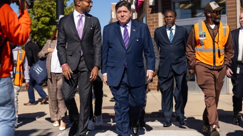 Gov. JB Pritzker (center) and running mate Christian Mitchell (left) head to an early voting site in Bronzeville last week.