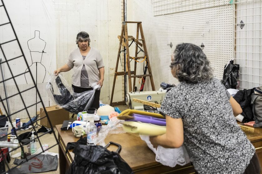 Norma Castillo (left) chats with a woman who stopped by to offer moral support as Castillo packed up her shop on March 28 to prepare to move out of the Little Village Discount Mall. Castillo had been in the mall since 1995 and has struggled to keep her business going from her Berwyn home.