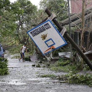 A resident walks beside a toppled basketball court after Typhoon Mangkhut barreled across Tuguegarao city, Cagayan province, northeastern Philippines, Saturday, Sept. 15, 2018. Philippine officials were assessing damage and checking on possible casualtie