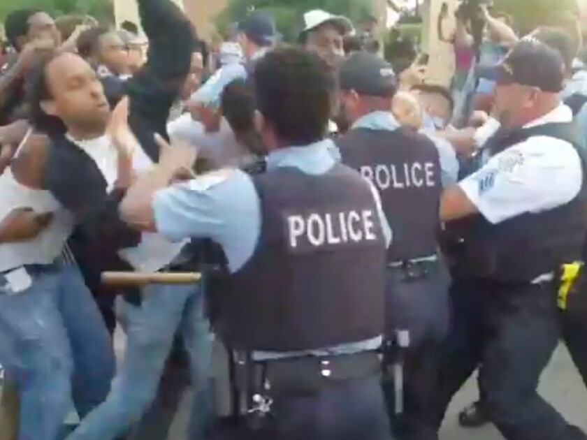Police push back protesters near the scene where an officer fatally shot a man Saturday evening in South Shore. | Nader Issa/Sun-Times