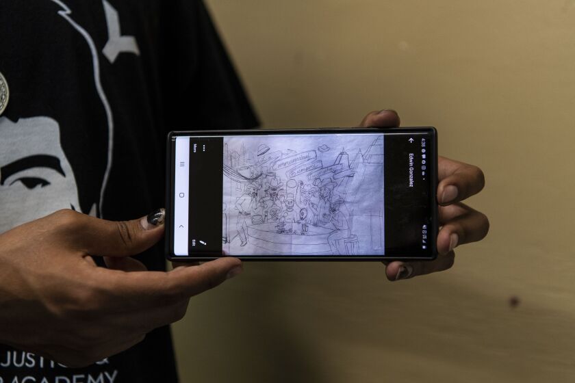 Jair Ramirez stands in the men’s bathroom of the Instituto Justice and Leadership Academy holding up a sketch of a mural design he’s going to be painting on the wall next to him, Thursday, Aug. 27, 2020. Ramirez is a recent graduate of the academy and is pushing for a Chicago Latinx exhibit at the Chicago History Museum.