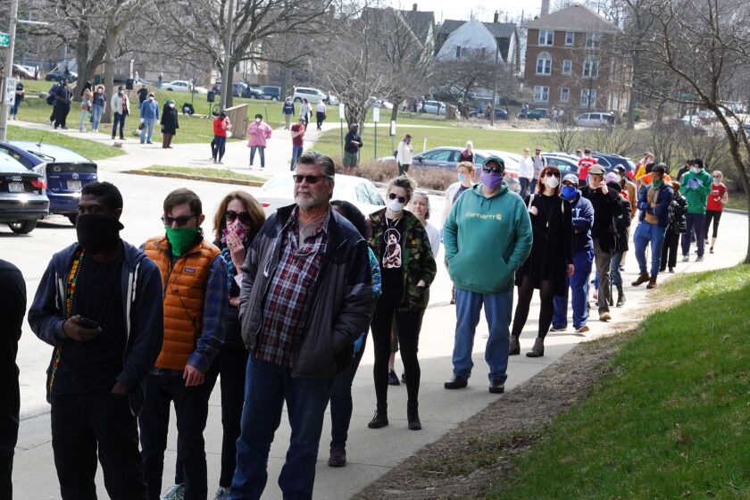 Voters wait in line at a polling place at Riverside University High School on April 07, 2020 in Milwaukee, Wisconsin.