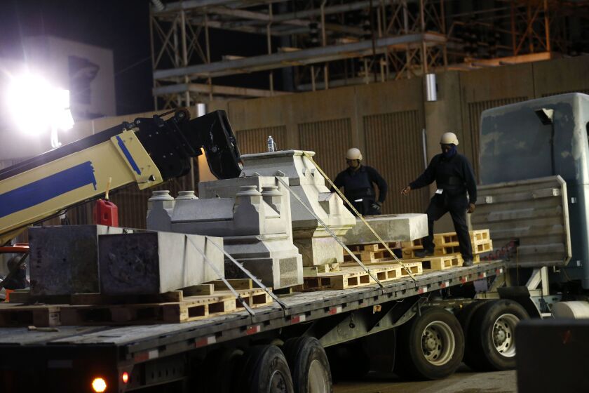 The pieces of the Liberty Place monument are hauled away early Monday in New Orleans. The monument commemorated whites who tried to topple a biracial post-Civil War government. New Orleans Mayor Mitch Landrieu says the dismantled monuments will be put int