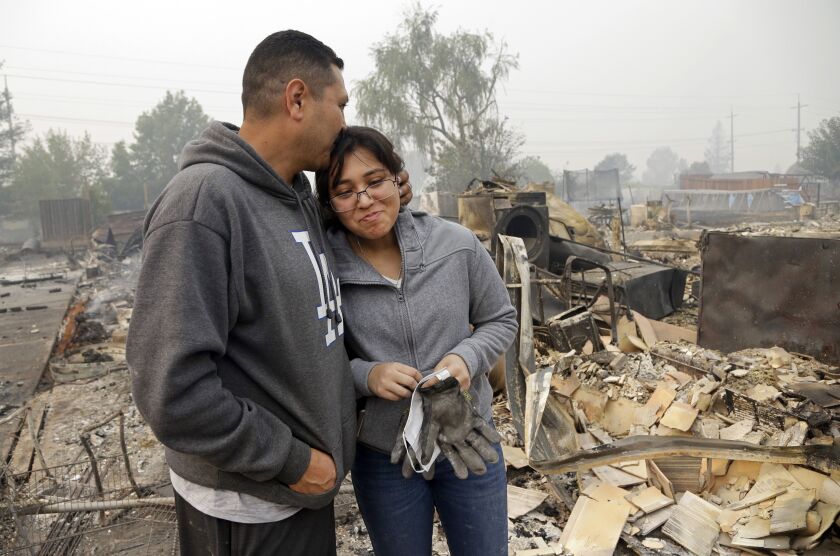 Jose Garnica, left, kisses his daughter Leslie Garnica in front of their home that was destroyed in the Coffey Park area of Santa Rosa, Calif., on Tuesday. | Ben Margot/Associated Press