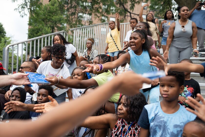 Kids reach for free school supplies during the annual Bud Billiken Parade along South Martin Luther King Jr. Drive in the Bronzeville neighborhood, Saturday, Aug. 12, 2023. | Pat Nabong/Sun-Times