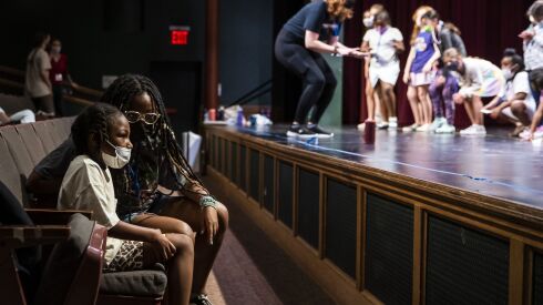 Junior counselor Noelle Hutchinson talks with 6-year-old Davion as other students play and dance during Hearts to Art, a summer camp at the Vittum Theater on July 11, 2022.