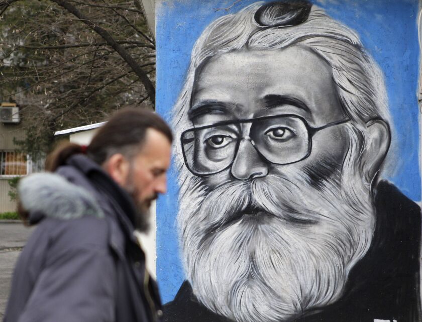 A man walks past a mural depicting Radovan Karadzic in Belgrade, Serbia, on Thursday. AP photo