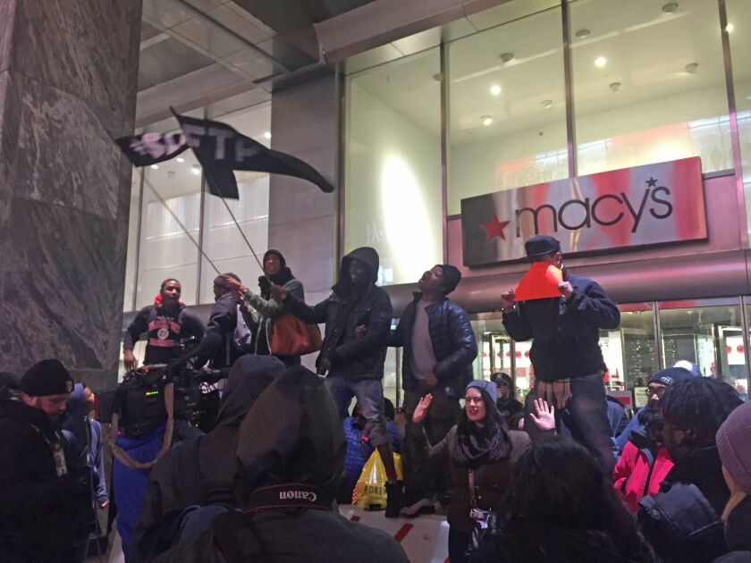 Many protesters remained on the Magnificant Mile for hours; here, some have returned to demonstrate in front of the Macy’s department store at Water Tower Place. | Mitchell Armentrout/For the Sun-Times