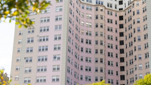 Close up view of the Edgewater Beach Apartments with one side freshly painted and the other with the old faded pink color.