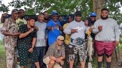 A group shot with most participating anglers clustered around Larry Powell (front row, second from right), who wears his second championship belt in three years and holds the winning salmon, Saturday at Jackson Park during the Slamming Salmon Nightmare Fishing LLC Tournament. Credit: Dale Bowman 