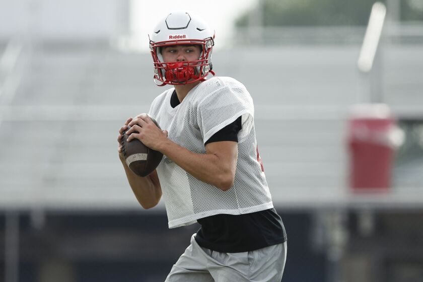 Palatine’s Tommy Elter looks to pass during football practice.