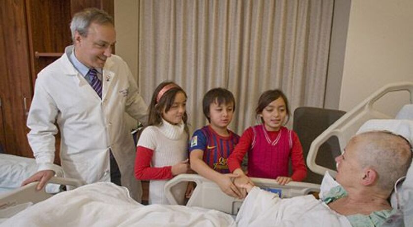 <small><strong>Dr. Andrew Parsa and his three children visit patient Julie Olson. | Photo courtesy of Northwestern Medicine Magazine</strong></small>
