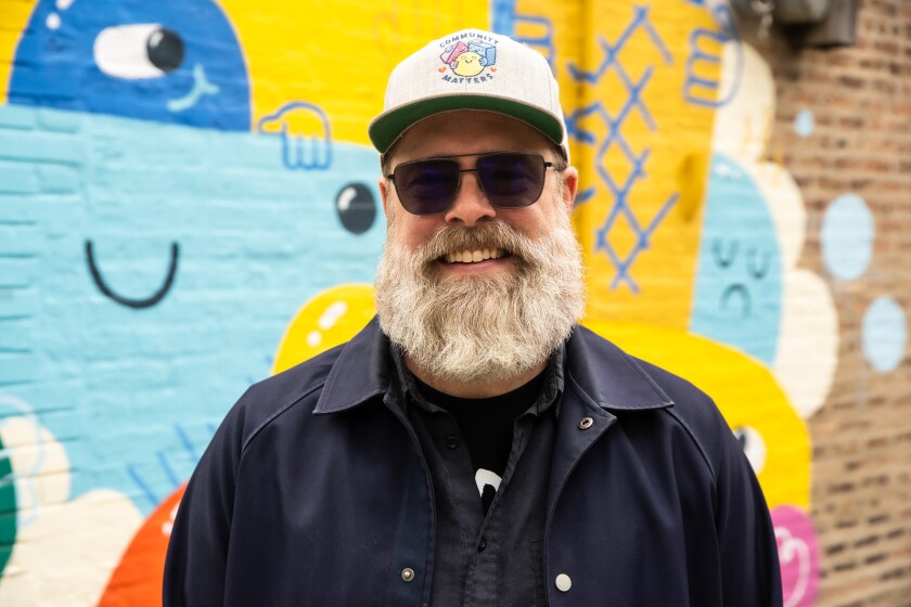 Artist Shawn Smith stands in front of his mural outside of Bartleby's Ice Cream Shop in North Center.