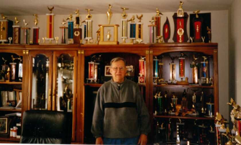 Tony Gacs in his office with many trophies won by his champion pigeons. | Family photo