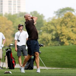 Mount Carmel assistant golg coach Jordan Lynch looks on after teeing off during practice at Jackson Park Golf Course.