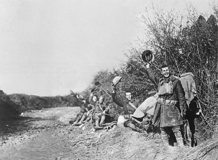 U.S. soldiers wave their helmets after the armistice was signed in France. Hundreds of troops died on the final morning of World War I — after the armistice was reached but before it took effect. | Associated Press file photo