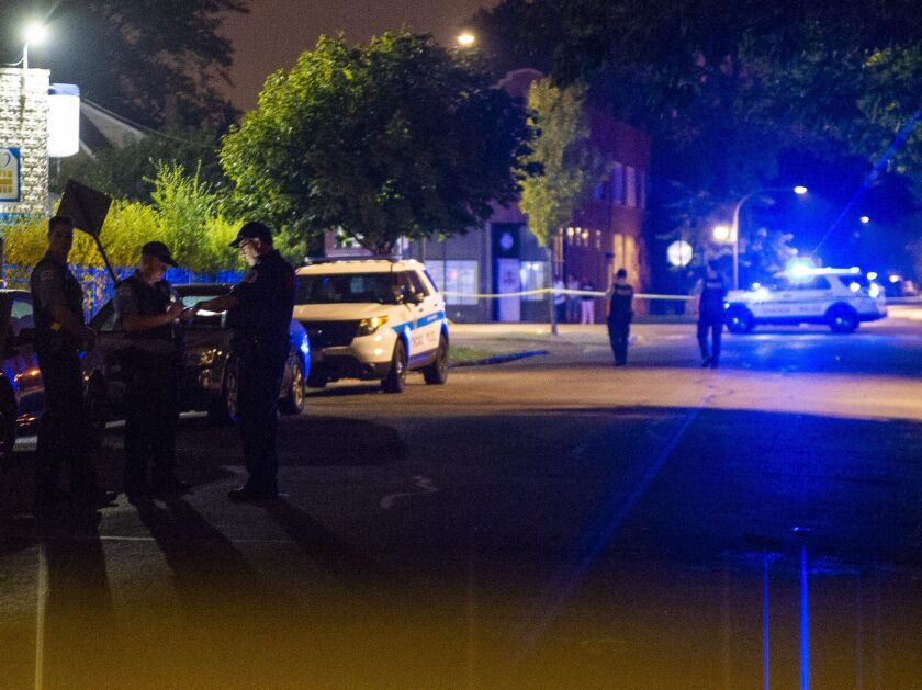 Police investigate a scene where two people were shot Monday night in the 1000 block of West 77th Street. | Tyler LaRiviere/Sun-Times