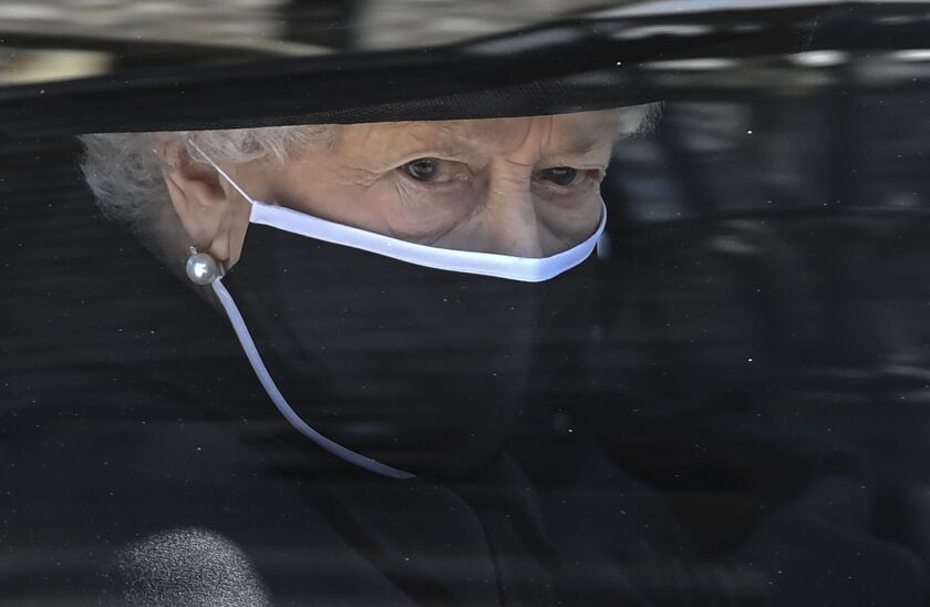 Britain’s Queen Elizabeth II follows the coffin in a car as it makes it’s way past the Round Tower during the funeral of Britain’s Prince Philip inside Windsor Castle in Windsor, England Saturday April 17, 2021.