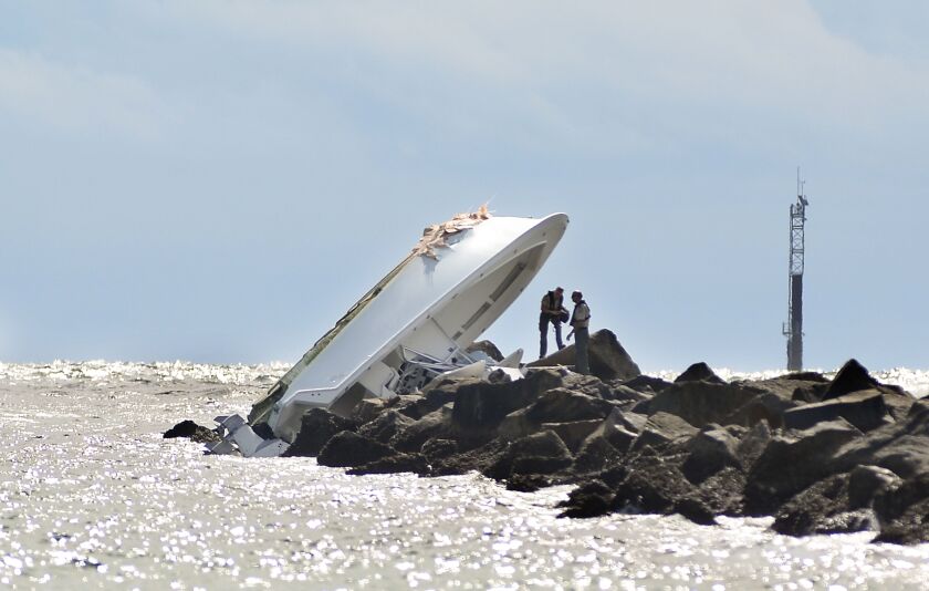 FILE – In this Sept. 25, 2016, file photo, investigators inspect an overturned boat as it rests on a jetty after a crash off Miami Beach, Fla. Miami Marlins pitcher Jose Fernandez was the “probable” operator of a speeding boat that crashed into a Miami Be