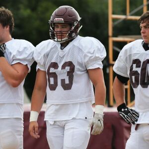 Loyola’s Christo Kelly (76), Josh Kreutz (63), and Peter Gianaris (60) get a break during practice.