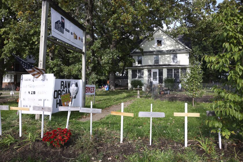 Signs, crosses line the front yard of a Plainfield home where two people were stabbed, one fatally, Saturday.