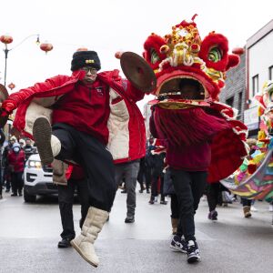 A performer jumps in the air as he performs a dance as the parade makes its way down the street during the Lunar New Year Celebration Parade in Chinatown on Sunday, Jan. 29, 2023.