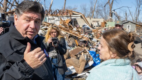 Gov. JB Pritzker speaks with Patricia Kime outside her destroyed home as local officials survey a tornado-damaged neighborhood near Norman Street and Strasma North Drive in Aroma Park, Ill. on Thursday, March 12, 2026