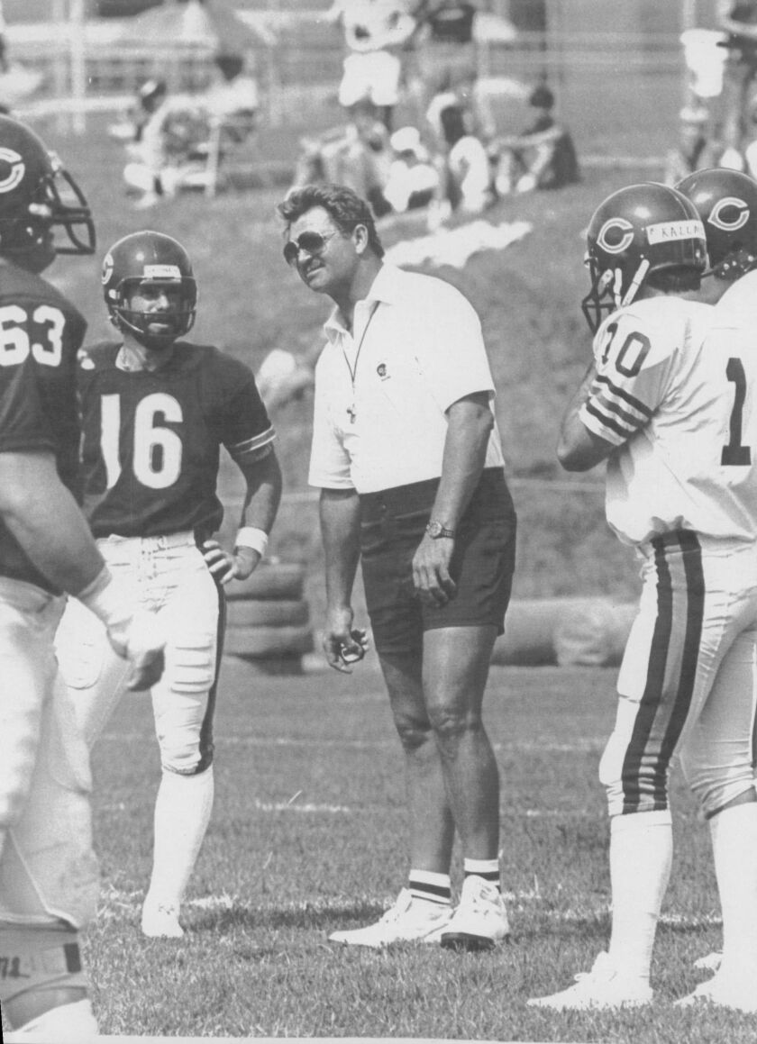 Chicago Bears head coach Mike Ditka talks with kicker Bob Thomas (16) and other Bears in 1985. File Photo.