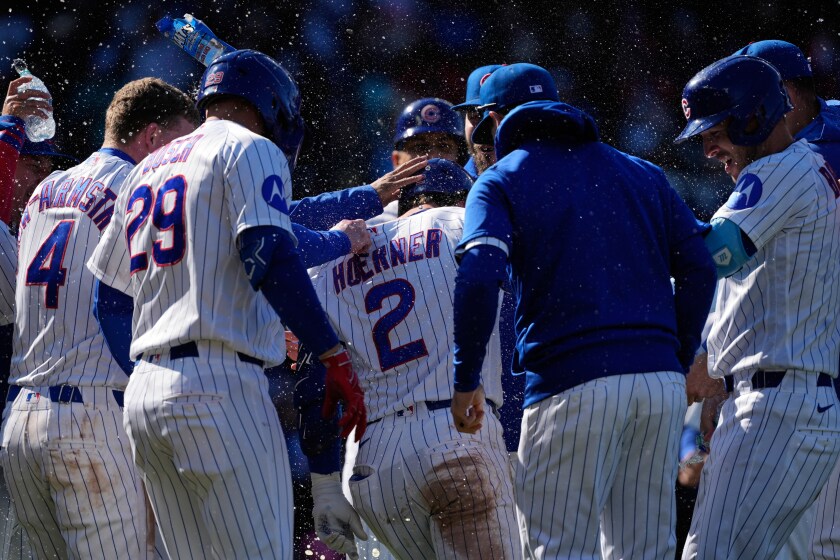 Nico Hoerner and the Cubs celebrate after Hoerner's sacrifice fly gave them a 2-1 win Sunday over the Mets.