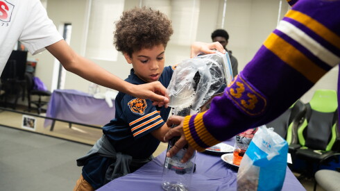 Cyrus Allen, 9, makes a filter with activated charcoal