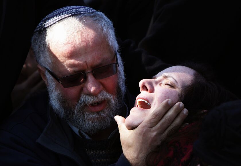 A man comforts Tali Kalangel the wife of 25-year-old Israeli army Captain Yochai Kalangel during his funeral at the Mount Herzl military cemetery in Jerusalem on January 29, 2015. GALI TIBBON/AFP/Getty Images