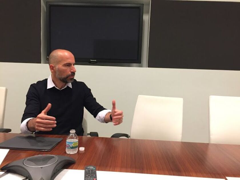 Uber CEO Dara Khosrowshahi talking at a table.
