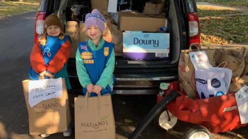 Two Oak Park Girl Scouts pose for a photo during the group's 2024 food drive. Oak Park parents said the group's food drive Saturday morning was cut short because of ICE activity in the area.