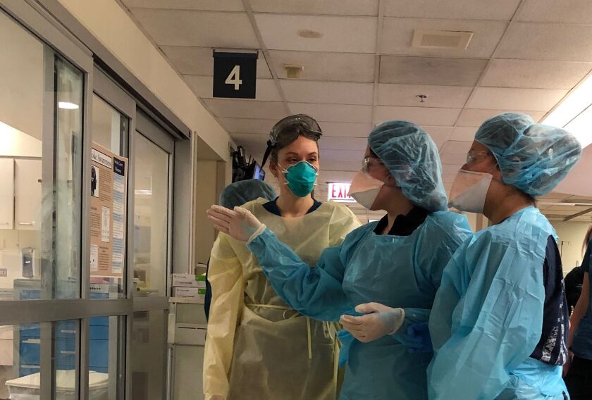 Medical staff wearing personal protective equipment consult in the emergency department of Mount Sinai Hospital, which is bracing for an influx of COVID-19 patients over the next two weeks.