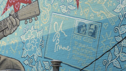 A postcard on the mural features John Prine’s signature and two stamps with the face of his old friend and fellow Chicago musician, Steve Goodman.