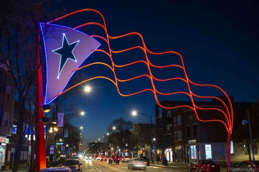 The Humboldt Park Puerto Rican flag seen at Western and Division, which acts as the neighborhood’s gateway, sits lit up for the first time since its installation in 1995.