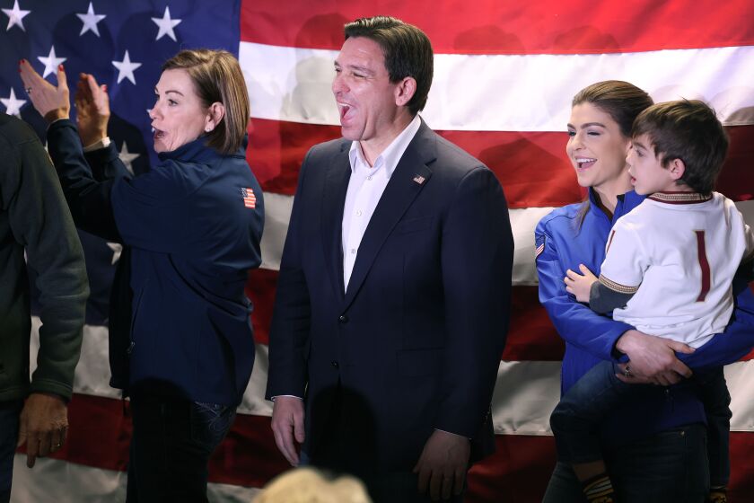 Florida Gov. Ron DeSantis (center) attends a rally in West Des Moines on Jan. 13, 2023 with his wife, Casey DeSantis (right) and Iowa Gov. Kim Reynolds (left).