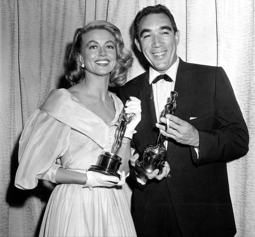 This March 27, 1957, file photo shows Best supporting Oscar winners Dorothy Malone and Anthony Quinn posing at the Academy Awards in Hollywood, Calif. | AP Photo, File)
