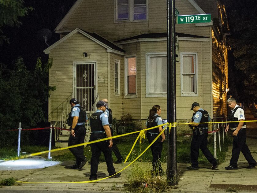 Police investigate a woman shot Monday morning in the 100 block of West 119th Street in West Pullman, Chicago. | Tyler LaRiviere/Sun-Times