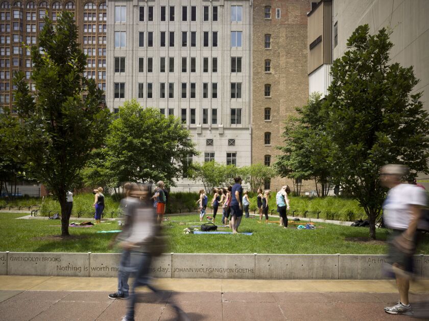 Programming, like this yoga class in Pritzker Park, has been used by the city to increase activity in the park.