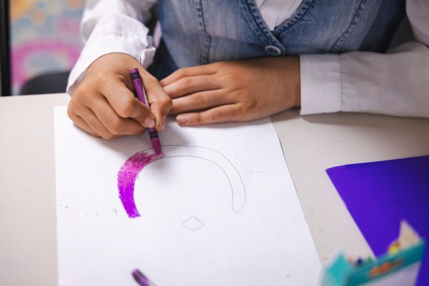 Learning Arabic letters by coloring them during an Arabic language day camp in Edgewater.
