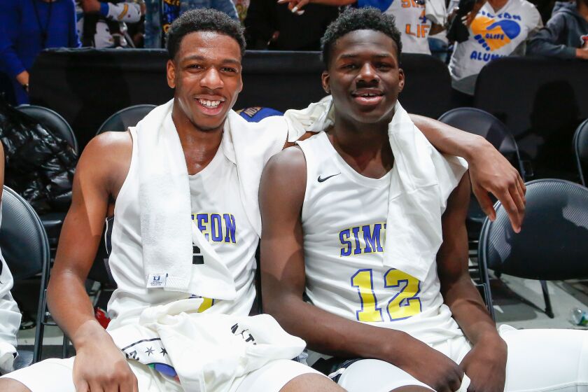 Simeon’s Jeremiah Williams (3) and Ahamad Bynum (12) enjoy a moment together after winning the game against Morgan Park.