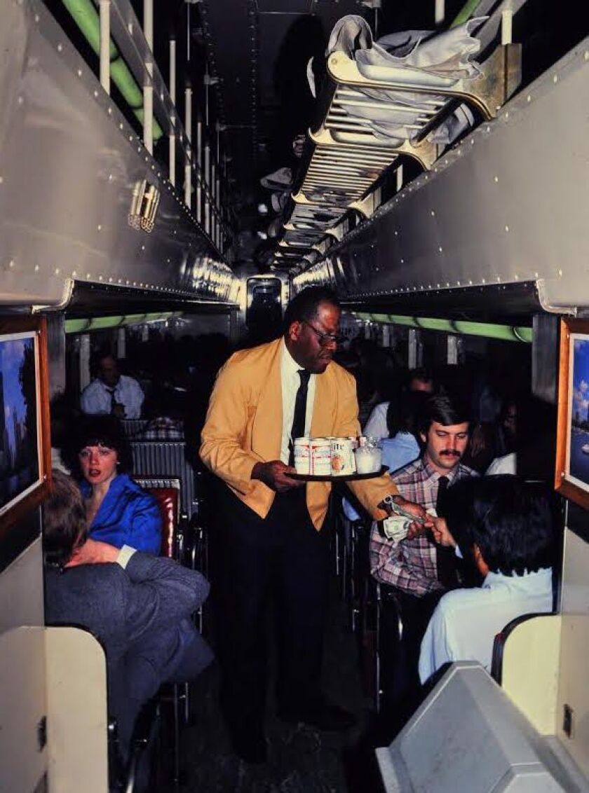 Leland “Sugar” Cain tending to riders in a bar car. | Mark Llanuza