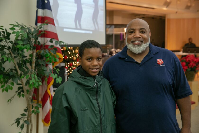Capt. Corey Hughes, pastor at the Salvation Army Red Shield Center in Englewood, here with Kavon Boswell, 12, says the center started its Celebrate Launch and Landing mentoring program three years ago as a way to draw more youths inside. | Nader Issa/Sun-
